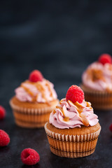 Raspberry and caramel cupcakes on dark background
