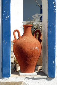 gr&ecirc;ce, Santorin, gros plan sur une amphore brune et barri&egrave;re bleue