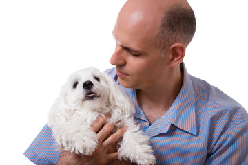 close up portrait of man looking to maltese dog in studio, isolated
