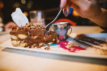 Close up focus view of desert chocolate cake with cute small milk can on the plate in a restaurant.