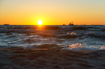 Sunset over the sea. Reflection of sunlight in the sea waves. Red sky in the rays of the sunset.