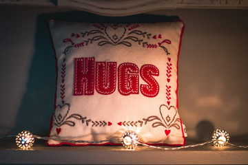'HUGS' Pillow Illuminated By Candles And Fairy Lights
