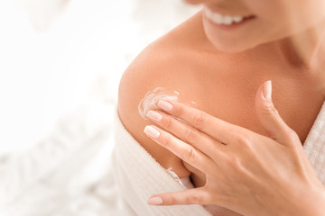 Natural beauty. Close up of female shoulder with a little of moisturizing cream being applied on it
