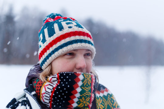 Portrait of girl in knitted hat in winter forest
