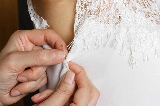 Female seamstress prepares dress to the fitting. Close up