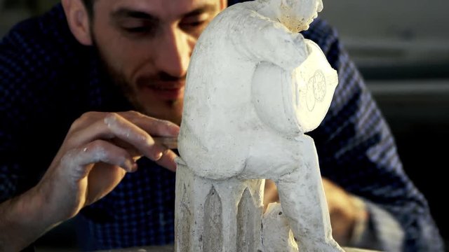 Sculptor works musician statue from gypsum