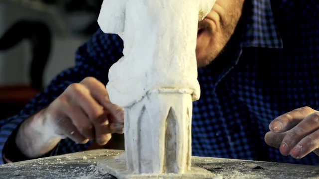 Sculptor works musician statue from gypsum