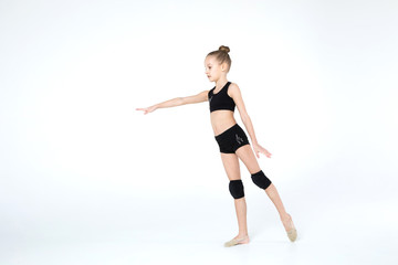 Fototapeta na wymiar Rhythmic gymnastics caucasian ballet dancer girl in black suite stretching in black costume on white background isolated showing flexible fitness