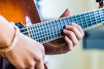 Close-up view of guitar and musician's hands