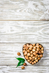 Bowl with hazelnuts on white wooden background.  Top view, copy space.