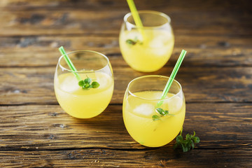 Glasses of orange cocktails with ice and mint