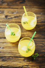 Glasses of orange cocktails with ice and mint