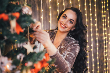 The charming girl decorating a Christmas tree