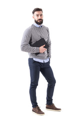 Handsome relaxed stylish bearded teacher with notebook looking at camera. Full body length portrait...