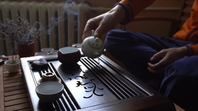 Man is Pouring Puer Tea in Teapot at Traditional Chinese Tea Ceremony. Set of Equipment for Drinking Tea