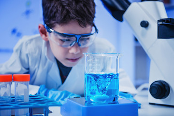 Schoolboy using lab equipment, laboratory education concept
