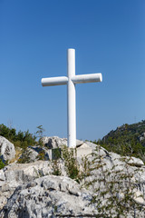White Christian cross symbol in mountains