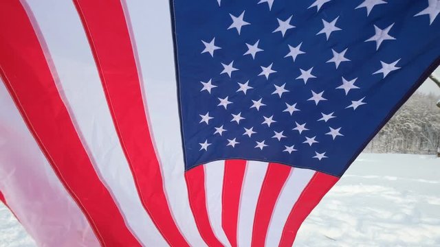 USA flag waving in the wind - highly detailed fabric texture. US flag on ski slope winter day.