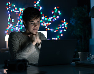 Woman connecting with her laptop at night