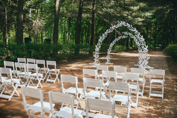 Beautiful wedding ceremony outdoors. Arch made of natural flowers. Decor