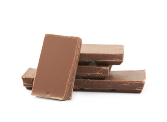 Pile of milk chocolate pieces isolated