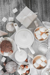 Cups with cacao and marshmallow, cupcakes and different decorations