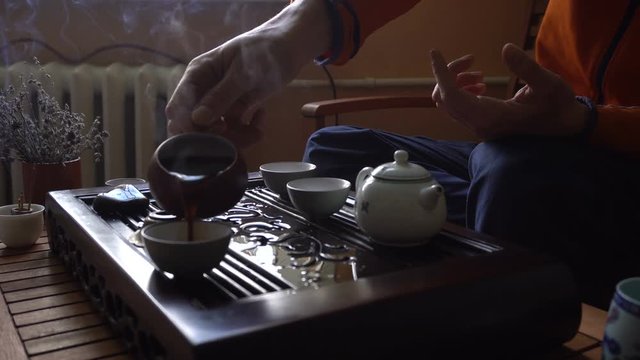 Man Pouring Puer Tea in Teapot at Traditional Chinese Tea Ceremony. Set of Equipment for Drinking Tea