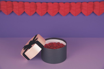 Pink gift box against ultra violet and lilac background.