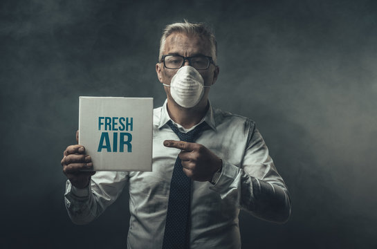Businessman holding a sign and air pollution