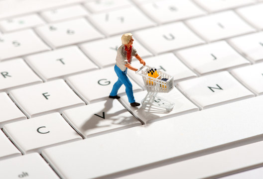 Shopper pushing a trolley over a computer keyboard - Powered by Adobe