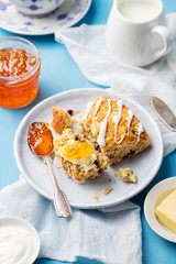 Scone with jam and butter on plate Blue background