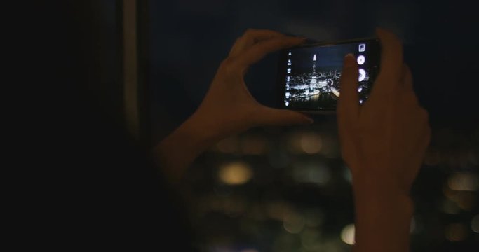 4K Unrecognizable young woman with smartphone taking photo of London skyline at night. Slow motion.
