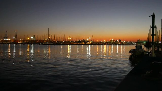 Gr&uacute;as y barcos en el puerto de Valencia atardecer 