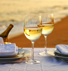 Romantic beach dinner with wine.