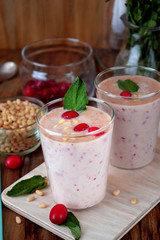 Protein cocktail for healthy nutrition decorated with cranberries, mint and pine kernel nuts in a glass