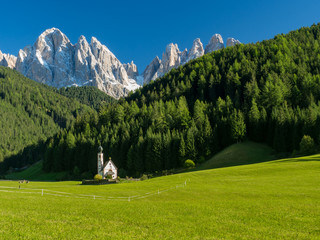 Green grass, blue sky. St Johann Church, Santa Maddalena, Val Di Funes, Dolomites, Italy....