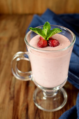 Protein cocktail with strawberries and mint in an Irish mug on wooden background