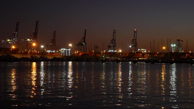 Gr&uacute;as y barcos en el puerto de Valencia atardecer 
