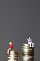 Gender pay equality concept. man and woman on a stack of coins.