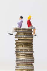 Gender pay equality concept. man and woman on a stack of coins.