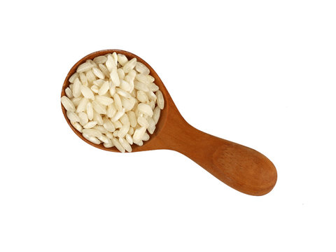 White Arborio rice in wooden scoop on white
