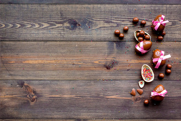 Chocolate Easter eggs on dark wooden background top view copy space