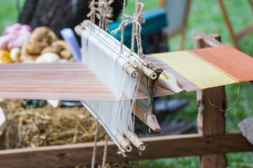 Fototapeta na wymiar Household Loom weaving - Detail of weaving loom for homemade silk or textile production of Thailand 