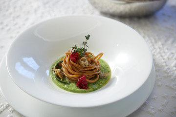 whole spahgetti with dried tomatoes and green beans sauce restaurant dish.