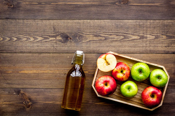 Bottle of fresh cider near autumn apples. Dark wooden background top view space for text