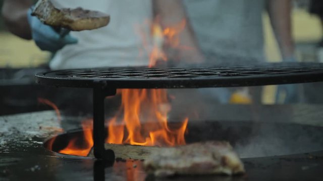 Juicy pork steak fried on large cast-iron round grill