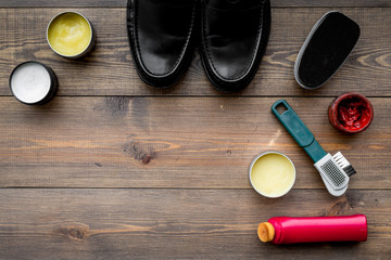 Plakat Shoe polish, brushes, wax near black shiny leather shoes on dark wooden background top view copy space