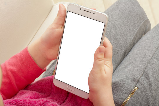 Little girl holding smartphone with isolated screen. Kid using phone with blank screen, mockup.