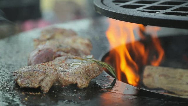 Juicy and appetizing meat fried with rosemary on fire