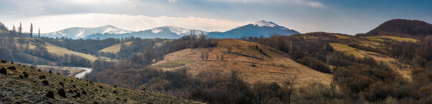 panorama of Borzhava mountain ridge in springtime. beautiful countryside with snowy tops and forested hills. location Volovets, Ukraine